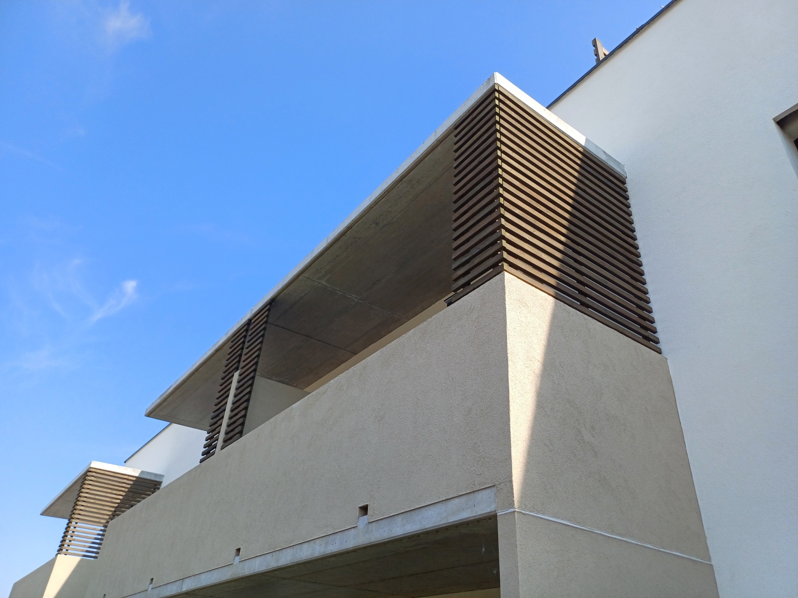 Dřevěné fasádní prvky budovy vystavené povětrnostním vlivům v exteriéru