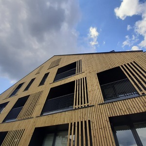 Fasáda apartmánového komplexu obložena hoblovanými prkny z borovice, která jsou ošetřena technologií vakuově-tlakové impregnace (Profi impregnace)
