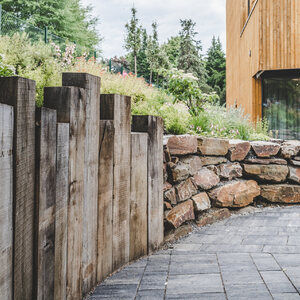 Ohraničení terénu ze zahradních pražců u příjezdové cesty k luxusnímu hotelovému komplexu JBX Resort Avenue v centru Lipna nad Vltavou.  