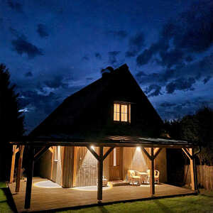 Noční pohled na rekreační chatu na břehu Lipna. Objekt je obložen fasádním obkladem KI Trend a jeho terasu zdobí terasová prkna KI Duo.