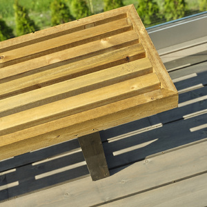 Ručně vyrobena lavička z prken ošetřených vakuově-tlakovou impregnací umístěna na terase z prken ošetřených olejově-vakuovou impregnací.