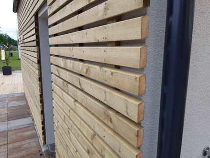 Detail fasádního obkladu RHOMBUS ze severského smrku. Produkt je ošetřen technologií Profi impregnace (vakuově-tlaková impregnace) Detail fasádního obkladu RHOMBUS ze severského smrku. Produkt je ošetřen technologií Profi impregnace (vakuově-tlaková impregnace)