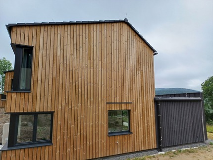 Fasáda rodinného domu na Šumavě obložena venkovními palubkami Vertikal z borovice. Palubky jsou ošetřeny vakuově-tlakovou impregnací (Profi impregnace) Fasáda rodinného domu na Šumavě obložena venkovními palubkami Vertikal z borovice. Palubky jsou ošetřeny vakuově-tlakovou impregnací (Profi impregnace)