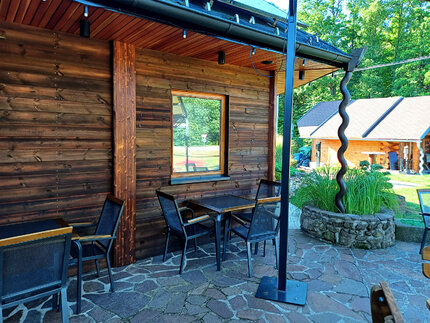 Detail obložení stylové restaurace Country Saloon Řípec fasádním obkladem KI Tradice v elegantní hnědé barvě. Obkladová prkna ze severské borovice (formát: síla 19 mm a šířka 148 mm) ošetřená Královskou impregnací, zaručují nejen dlouhou životnost, ale i 