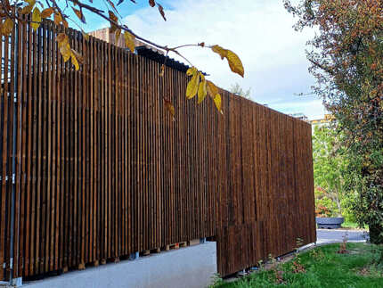 Opláštění části fasády prodejny Billa v Žatci obkladovými fasádními hranoly KI (formát 45x45 mm) v hnědém odstínu. Ošetření hranolů Královskou impregnací poskytuje poskytuje dlouholetou ochranu dřeva v exteriéru.   