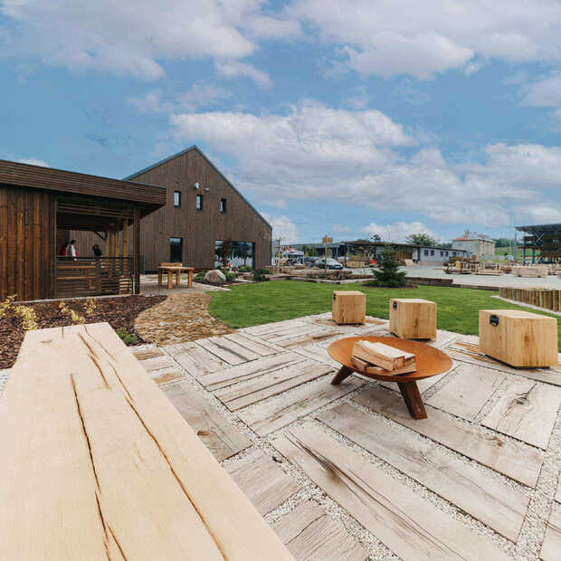 Ukázka praktického využití zahradních pražců v prostorách firemního showroomu Impregnace Soběslav, v pozadí elegantní masivní kostky k sezení. 