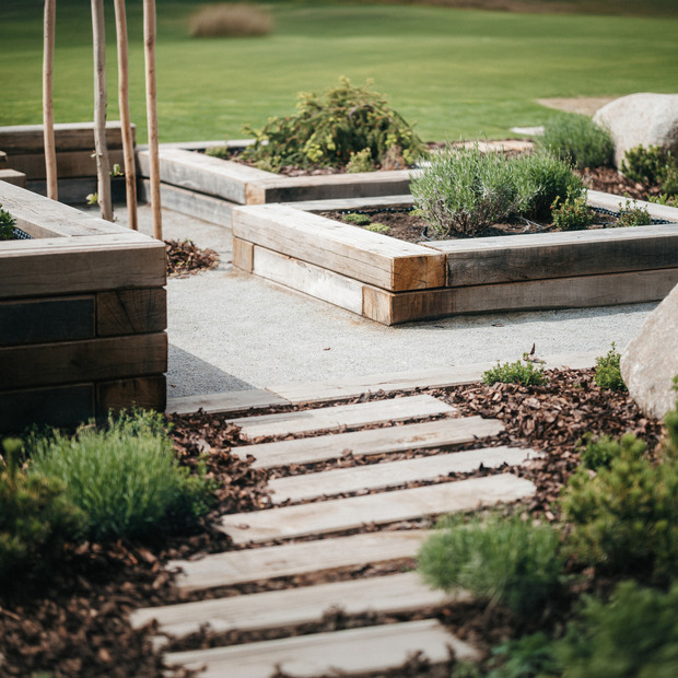 V popředí chodník ze zahradních pražců, v pozadí ohraničení záhonů z půlených pražců, zakázková výroba Impregnace Soběslav.
